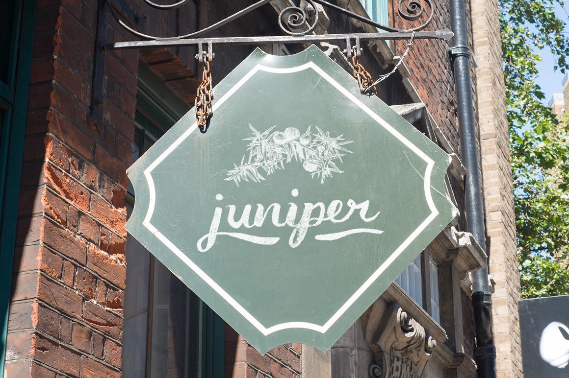 Green tavern sign using Juniper illustration and script font